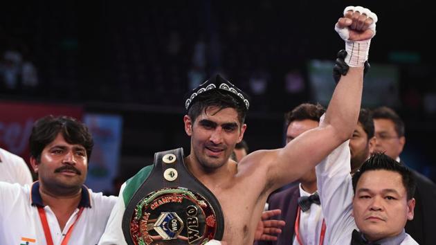 The referee raises the hand of Vijender Singh (C) who beat Zulpikar Maimaitiali by a unanimous verdict — 96-93, 95-94, 95-94. (AFP)