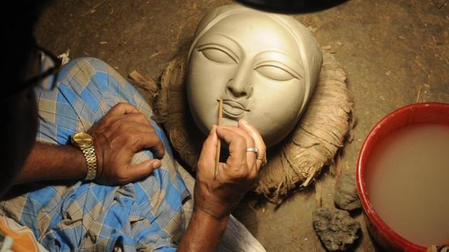 A clay idol maker is busy to finish face of Durga at Kumartuli, a hub of artists in Kolkata. (Samir Jana/HT PHOTO) A clay idol maker is busy to finish face of Durga at Kumartuli, a hub of artists in Kolkata. (Samir Jana/HT PHOTO)