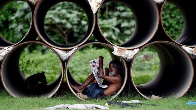 An Indian man reads a newspaper as he sits inside a pipe in New Delhi. (Money SHARMA/ AFP) An Indian man reads a newspaper as he sits inside a pipe in New Delhi. (Money SHARMA/ AFP)
