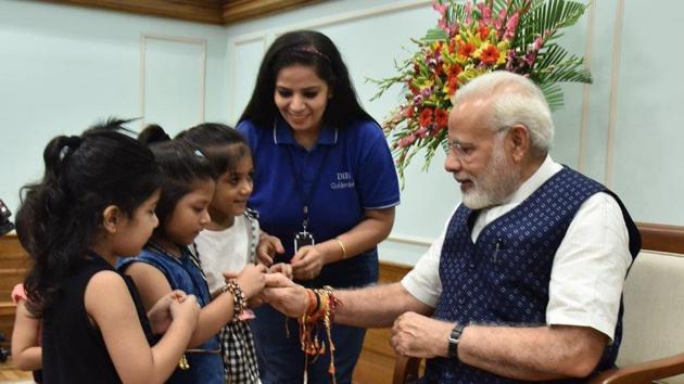 Young girls tie rakhis on Prime Minister Narendra Modi’s wrist. (Twiiter/PMO India) Young girls tie rakhis on Prime Minister Narendra Modi’s wrist. (Twiiter/PMO India)