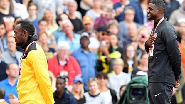 Justin Gatlin (R) and Usain Bolt smile as the American national anthem gets played during the podium ceremony of the men’s 100m event at the IAAF World Championships of Athletics in London on Sunday. (Getty Images)
