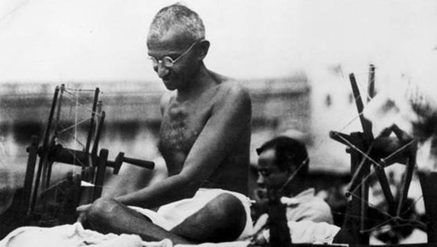 Mahatma Gandhi using a spinning wheel during a demonstration in Mirzapur, Uttar Pradesh on June 9, 1925.(Getty Images)