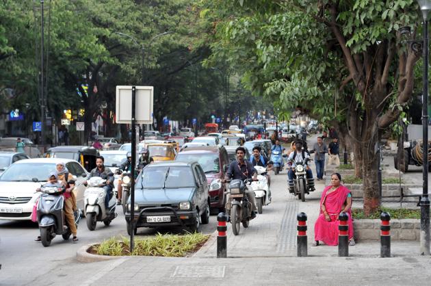 two wheeler riders have been blatantly mis-using the broadened footpath to bypass the slow-moving traffic during peak hours.(HT Photo)