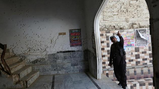 A policeman gestures beside a wall with shrapnel scars caused by a suicide blast at a Shi'ite mosque in Shikarpur, Pakistan. (REUTERS) A policeman gestures beside a wall with shrapnel scars caused by a suicide blast at a Shi'ite mosque in Shikarpur, Pakistan. (REUTERS)