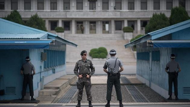 In a photo taken on August 2, 2017 South Korean soldiers stand guard before North Korea's Panmon Hall (rear C) and the military demarcation line separating North and South Korea, at Panmunjom, in the Joint Security Area (JSA) of the Demilitarized Zone (DMZ). (AFP Photo)