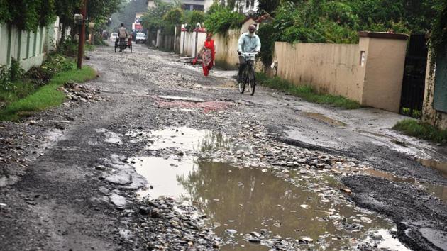 A view of pothole filled Canal Road in Dehradun.(Vinay Santosh Kumar/HT PHOTO)