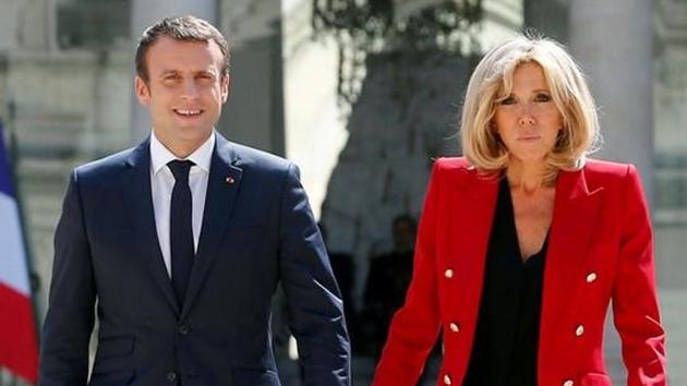 French President Emmanuel Macron and his wife Brigitte Macron walk in the Elysee Palace courtyard July 6, 2017.(Reuters)