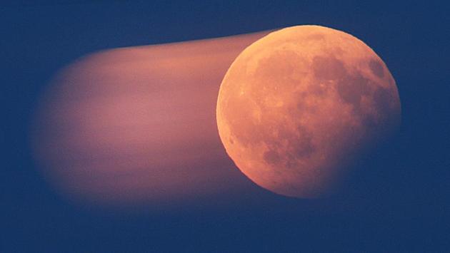 Picture taken with long exposure time shows the rising full moon entering a partial lunar eclipse (right side) over Frankfurt, Germany. (Michael Probs/AP)