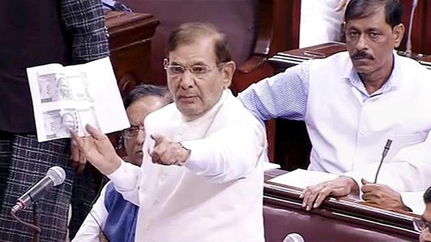 JD (U) leader Sharad Yadav brandishes copies of two different kinds of 500 and 1000 rupee notes, while speaking in the Rajya Sabha during the ongoing monsoon session of Parliament, in New Delhi on Tuesday.(PTI Photo)