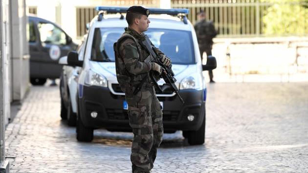 An armed French soldier stands near the site where a car slammed into soldiers on patrol in Levallois-Perret, outside Paris, on August 9, 2017.(AFP)