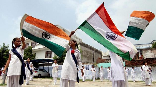 School children wave the national flag during a rehearsal for celebrations to be held on the occasion of 70th Independence Day at a government school, in Jammu. (PTI)