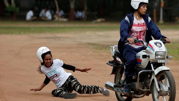 A policewoman reacts after a fall from a motorcycle while taking part in a rehearsal for Independence Day celebrations in Ahmedabad, Gujarat. (Amit Dave/REUTERS)