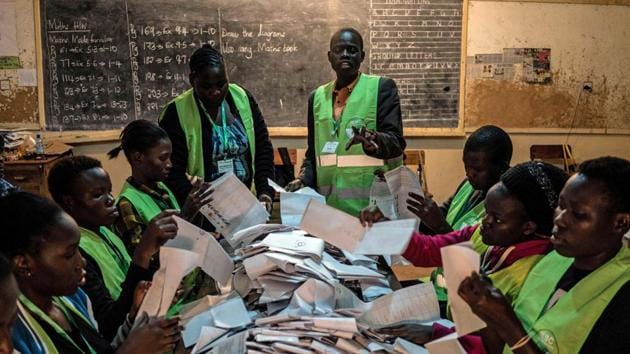 Voting officials count ballots at the Victoria primary school polling station in Kisumu. After the voting, officials ensured that the ballots were properly counted, which was being done manually and matched with electronic data in an effort to ensure no ballot stuffing occurred. (Fredrik Lernery/AFP)