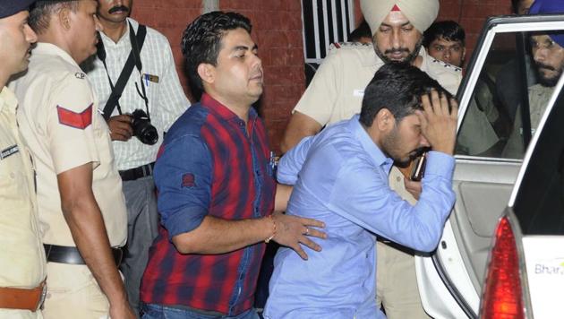 Vikas Barala (in blue shirt) being taken into police custody on Wednesday. (Keshav Singh/HT) Vikas Barala (in blue shirt) being taken into police custody on Wednesday. (Keshav Singh/HT)