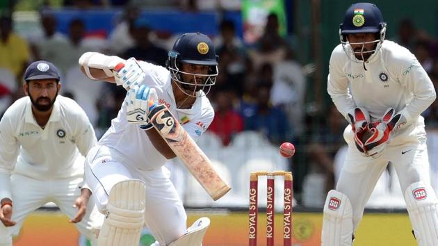 Dimuth Karunaratne (C) is watched by Wriddhiman Saha (R) as he plays a shot during the fourth day of the second Test match between Sri Lanka and India. (AFP) Dimuth Karunaratne (C) is watched by Wriddhiman Saha (R) as he plays a shot during the fourth day of the second Test match between Sri Lanka and India. (AFP)