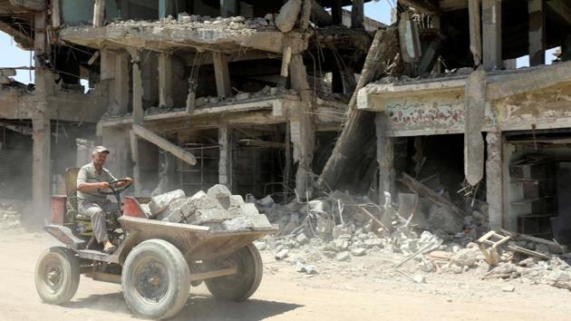 A construction worker transports bricks for the reconstruction of destroyed building in the Old City of Mosul. (REUTERS)