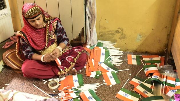 Demand for the tricolor comes in all sizes. From large cloth banners that take place on masts high up the skyline to small hand held versions that are sold by at every corner by hawkers. A woman prepares versions of the latter at her residence which also doubles as a workshop. (Burhaan Kinu / HT Photo)