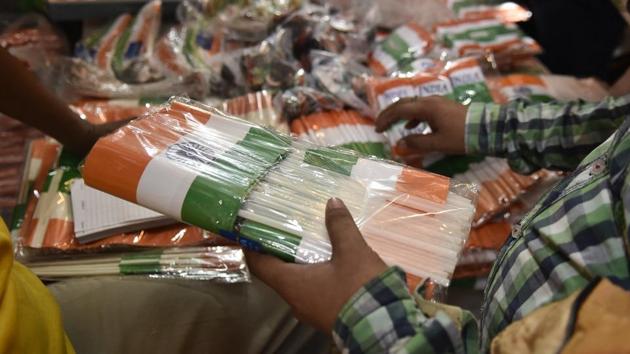 A person buys Indian national flags in bulk at a market for the upcoming Independence day celebrations, in New Delhi. Tricolour related paraphernalia ranging from flags to face paint, clothing and banners sees exceptionally high demand among buyers in the days leading up to the eve of August 15. (Burhaan Kinu / HT Photo)