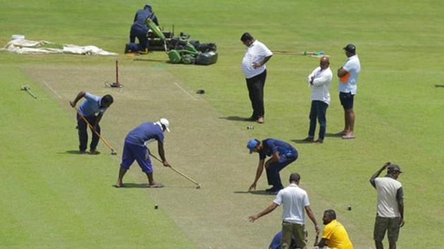 Sri Lankan cricket captain Dinesh Chandimal, wearing a blue cap, inspects the pitch ahead of the third test cricket match against India in Pallekele. (AP)