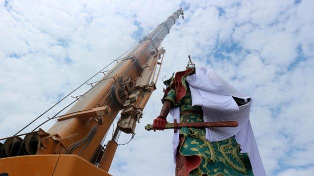 A crane is used to cover the statue of Guan Yu, a Chinese deity, in Tuban, Indonesia on August 6, 2017. (Reuters) A crane is used to cover the statue of Guan Yu, a Chinese deity, in Tuban, Indonesia on August 6, 2017. (Reuters)