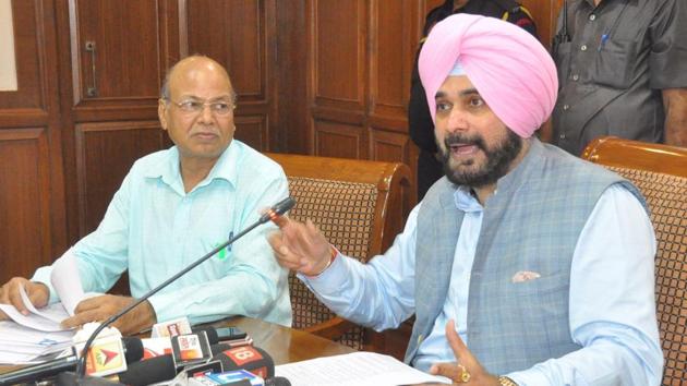 Minister Navjot Singh Sidhu, accompanied by former customs officer SL Goyal, speaking at a press conference in Chandigarh on Saturday.(HT Photo)
