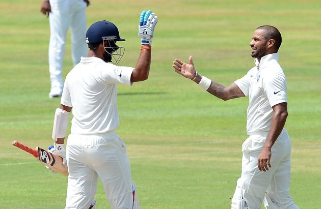 Indian cricketer Shikhar Dhawan (R) is congratulated by his teammate Cheteshwar Pujara after he scored his century. (AFP)