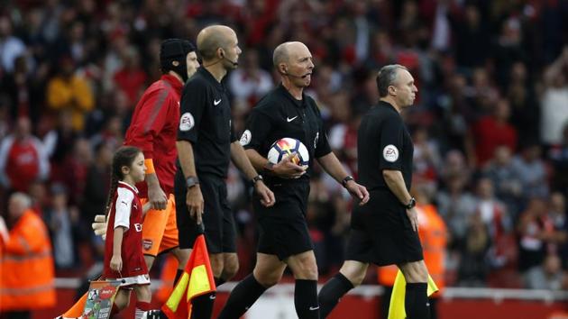 Referee Mike Dean (2nd R) was at the center of attention of failing to spot a handball by Mesut Ozil in the run up to Arsenal’s third goal. (AFP)