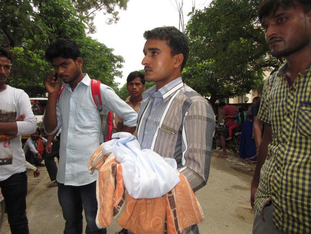 A man holds a dead baby outside the BRD Medical College in Gorakhpur, Uttar Pradesh. The jury is out on whether the 63 such deaths here this past week were a result of callousness, negligence or disease, but there’s no getting away from the fact that the children would still be alive if they had not contracted encephalitis.(AFP)