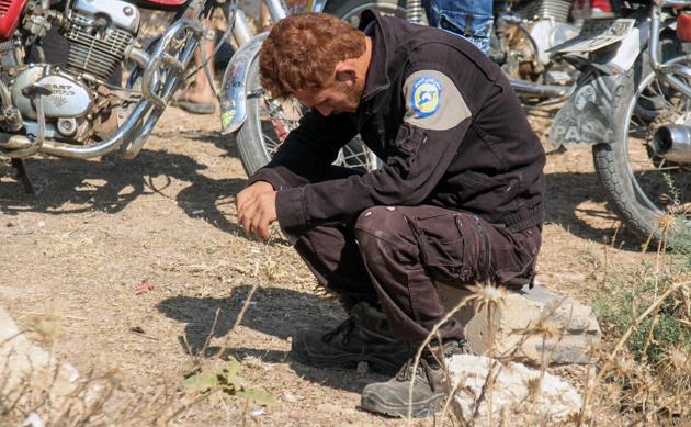 A member of the Syrian civil defence volunteers, also known as the White Helmets, mourns as colleagues bury his fellow comrades in Sarmin, a jihadist-held town 9 km east of Idlib on August 12, 2017. (AFP) A member of the Syrian civil defence volunteers, also known as the White Helmets, mourns as colleagues bury his fellow comrades in Sarmin, a jihadist-held town 9 km east of Idlib on August 12, 2017. (AFP)