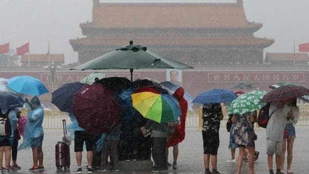 Tourists hold umbrellas as they visit Tiananmen Square during a rainstorm in Beijing on Saturday. (Reuters) Tourists hold umbrellas as they visit Tiananmen Square during a rainstorm in Beijing on Saturday. (Reuters)