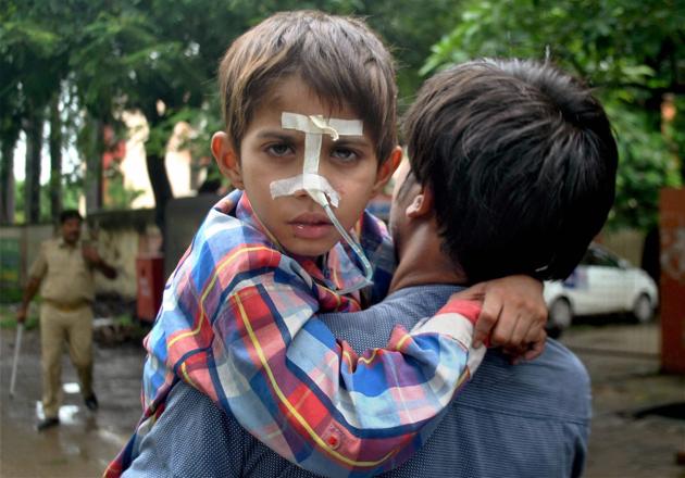 A child is being shifted to another ward at Baba Raghav Das Medical College Hospital in Gorakhpur district on Sunday.(PTI Photo)