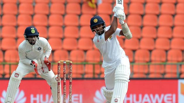 Sri Lanka cricket team skipper Dinesh Chandimal (R) is watched by Indian wicketkeeper Wriddhiman Saha as he plays a shot. (AFP)