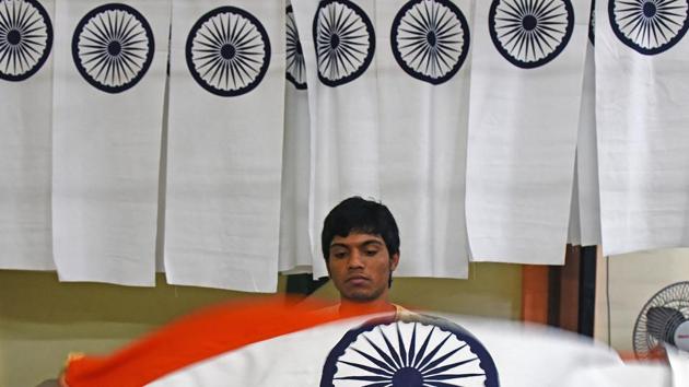 A worker unfurls the flag to check if it’s in pristine condition. (Satyabrata Tripathy/HT)