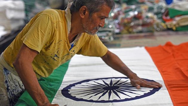 A man scrutinises the flag to ensure that everything is perfect. (Satyabrata Tripathy/HT )