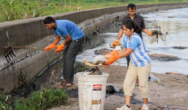 Volunteers of Jeevitnadi cleaning the river stretch at Vitthalwadi in Pune.(Sanket Wankhade/HT PHOTO)