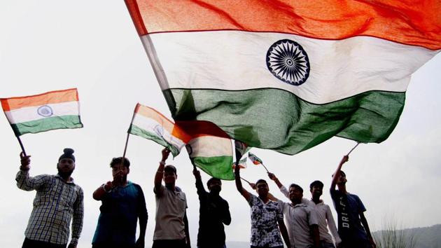 Youngsters wave the national flag ahead of India's Independence Day, in Jammu on Saturday.India celebrates its 71st year of Independence this August 15. (PTI)