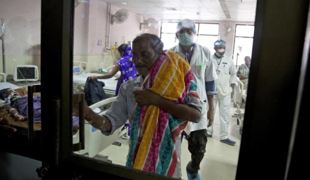 A man leaves a hospital ward with the lifeless body of his one-month-old nephew at Baba Raghav Das Medical College Hospital in Gorakhpur where at least 60 children died in the last week. The deaths coincided with a shortage of oxygen mid-week, after supply from a private firm was cut off due to pending dues.(AP photo)