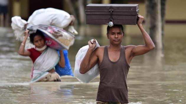 Villagers wade through flood waters while carrying household items at the flood affected Koliabor village, 186km from Guwahati, on Sunday. (AFP Photo) Villagers wade through flood waters while carrying household items at the flood affected Koliabor village, 186km from Guwahati, on Sunday. (AFP Photo)