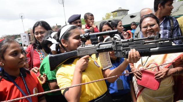 A girl tries holding a rifle at the at 'Know Your Army' exhibition. (HT PHOTO)