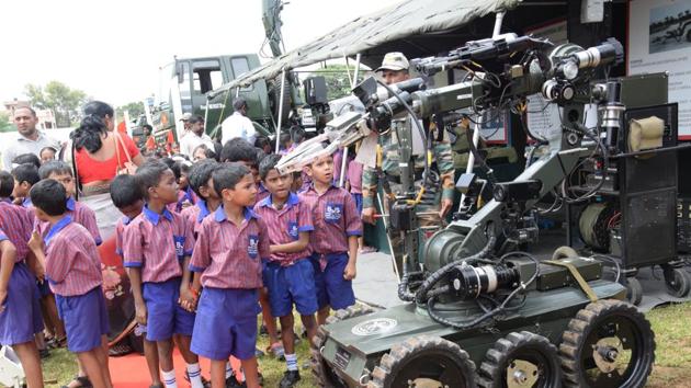 Children try to understand the working of an advanced remote controlled machine at the ‘Know Your Army' exhibition. (HT PHOTO)