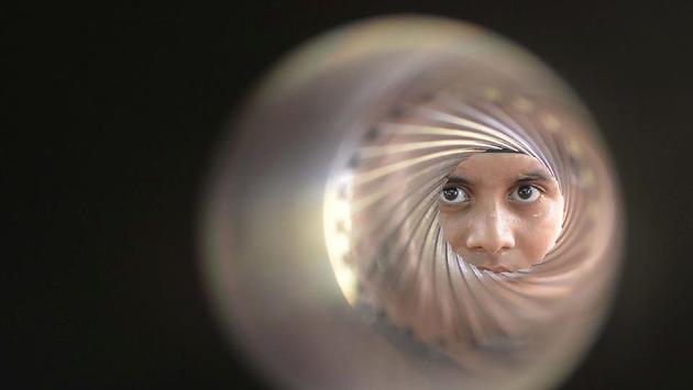 An Indian student poses as he looks down the barrel of an 84-MM rocket launcher during an Indian Army exhibition at Panther Stadium in Amritsar on August 10. (Narinder Nanu/AFP)