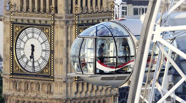 British athlete Mo Farah stands atop of a pod on the London Eye, with Big Ben's clock tower in background, as he bids a final farewell to British track competitive athletics after winning gold in the 10,000m and silver in the 5,000m at the IAAF World Championships in London, Sunday Aug. 13, 2017. (AP) British athlete Mo Farah stands atop of a pod on the London Eye, with Big Ben's clock tower in background, as he bids a final farewell to British track competitive athletics after winning gold in the 10,000m and silver in the 5,000m at the IAAF World Championships in London, Sunday Aug. 13, 2017. (AP)