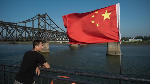 This file picture taken on July 6, 2017 shows a tourist looking out from the Broken Bridge next to the Friendship bridge (L) on the Yalu River connecting the North Korean town of Sinuiju and the Chinese border city of Dandong. (AFP)