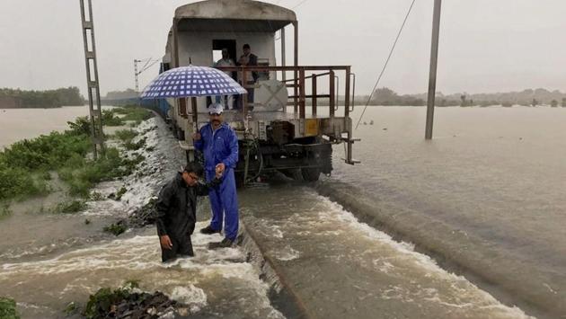 A goods train halts on the flooded tracks as railway empolyees inspect the damaged embankment along the Katihar-Guwahati line, in Katihar district of Bihar. (PTI)