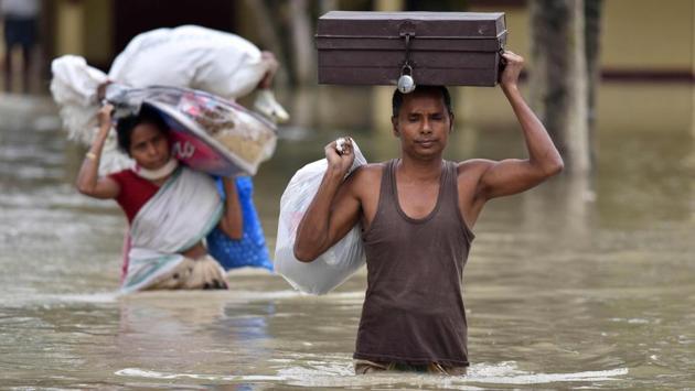 Villagers wade through flood waters carrying household items at Koliabor village in the northeastern state of Assam. Floods also affected Tripura, forcing 9,917 families to take shelter in 75 relief camps. (Biju Boro/AFP)