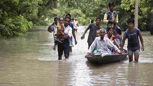Commuters wade through flood waters on a road in Murkata village east of Guwahati on Monday. (AP Photo) Commuters wade through flood waters on a road in Murkata village east of Guwahati on Monday. (AP Photo)