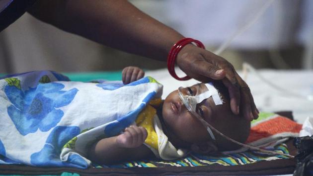A woman looks after her child at the encephalitis ward of the Baba Raghav Das Hospital in Gorakhpur, on Monday.(AFP Photo) A woman looks after her child at the encephalitis ward of the Baba Raghav Das Hospital in Gorakhpur, on Monday.(AFP Photo)