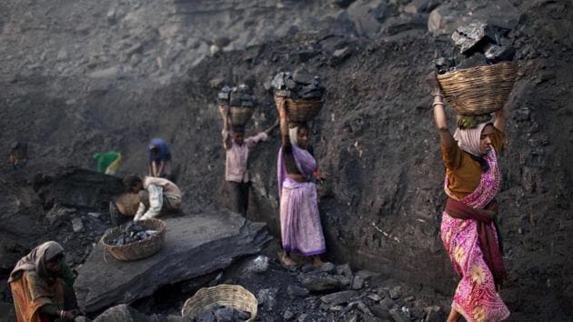 People carry baskets of coal scavenged illegally at an open-cast mine in the village of Bokapahari in Jharkhand, 2011(AP)