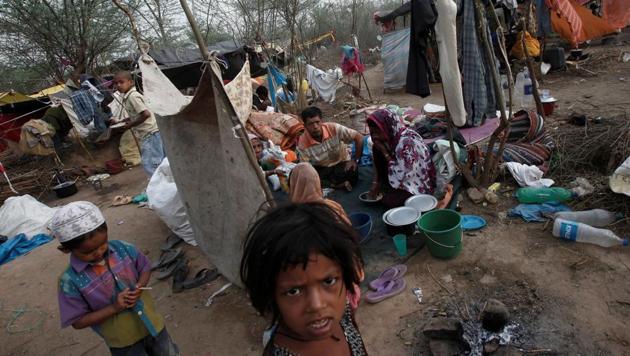 A family, who says they belong to the Burmese Rohingya Community from Myanmar, eats their breakfast at a makeshift shelter in a camp in New Delhi.(REUTERS)