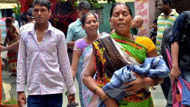 Relatives carry a child at the Baba Raghav Das Medical College Hospital, in Gorakhpur district on Monday. (PTI) Relatives carry a child at the Baba Raghav Das Medical College Hospital, in Gorakhpur district on Monday. (PTI)